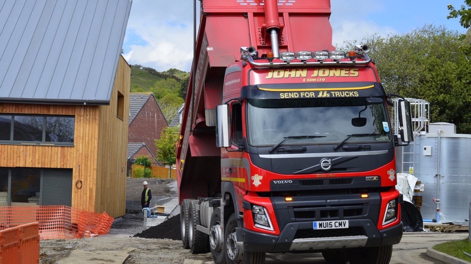 John Jones tipper lorry delivering topsoil to a development site